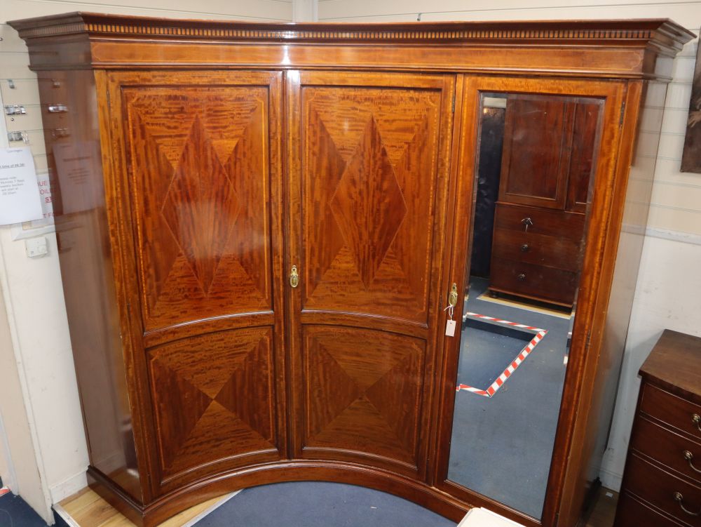 An unusual Sheraton revival fiddle back mahogany corner triple wardrobe, W.280cm, maximum depth 125cm, H.214cm